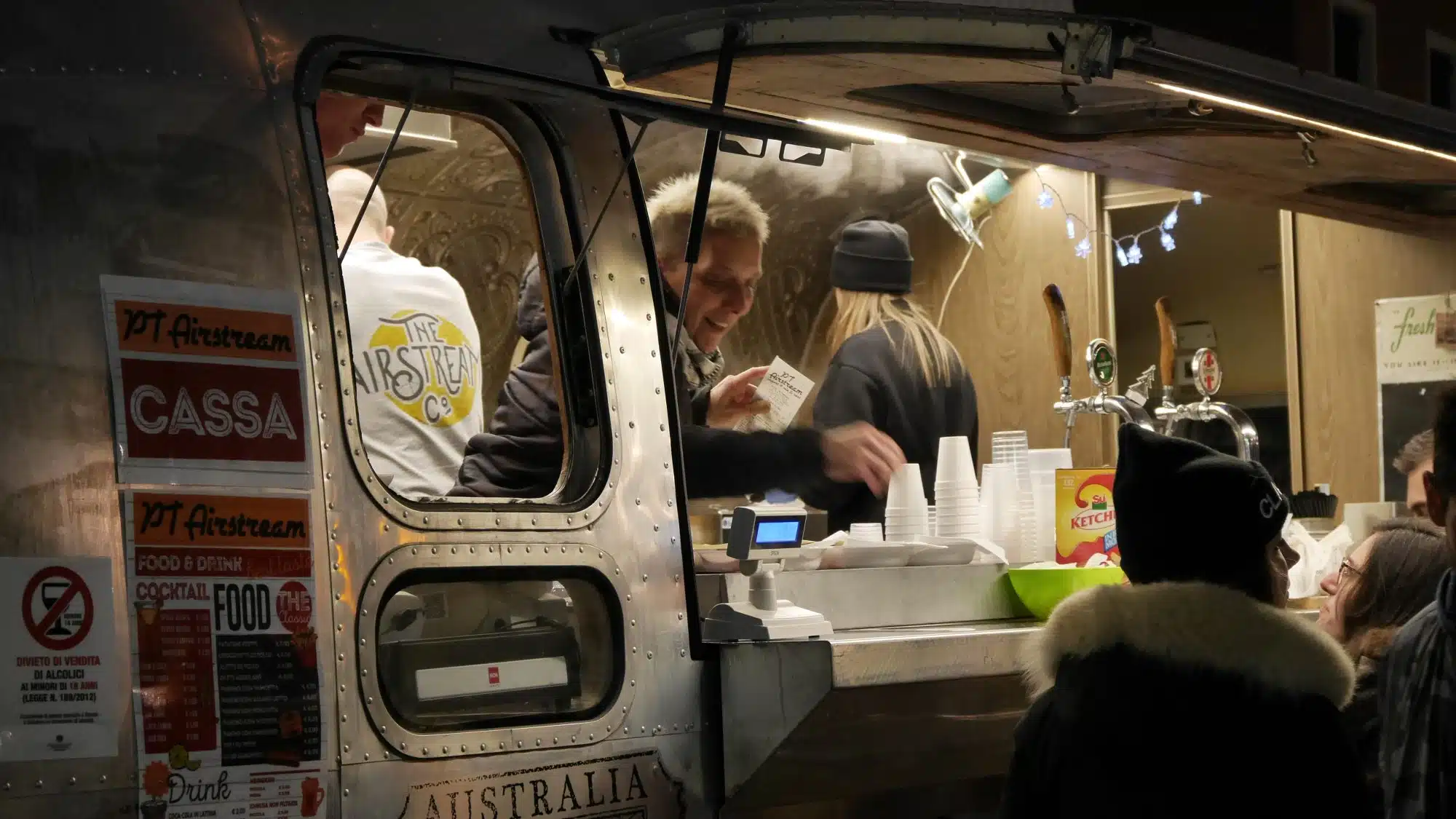Live Near Austin's Best Food Truck Parks - people buying from a food truck at night.